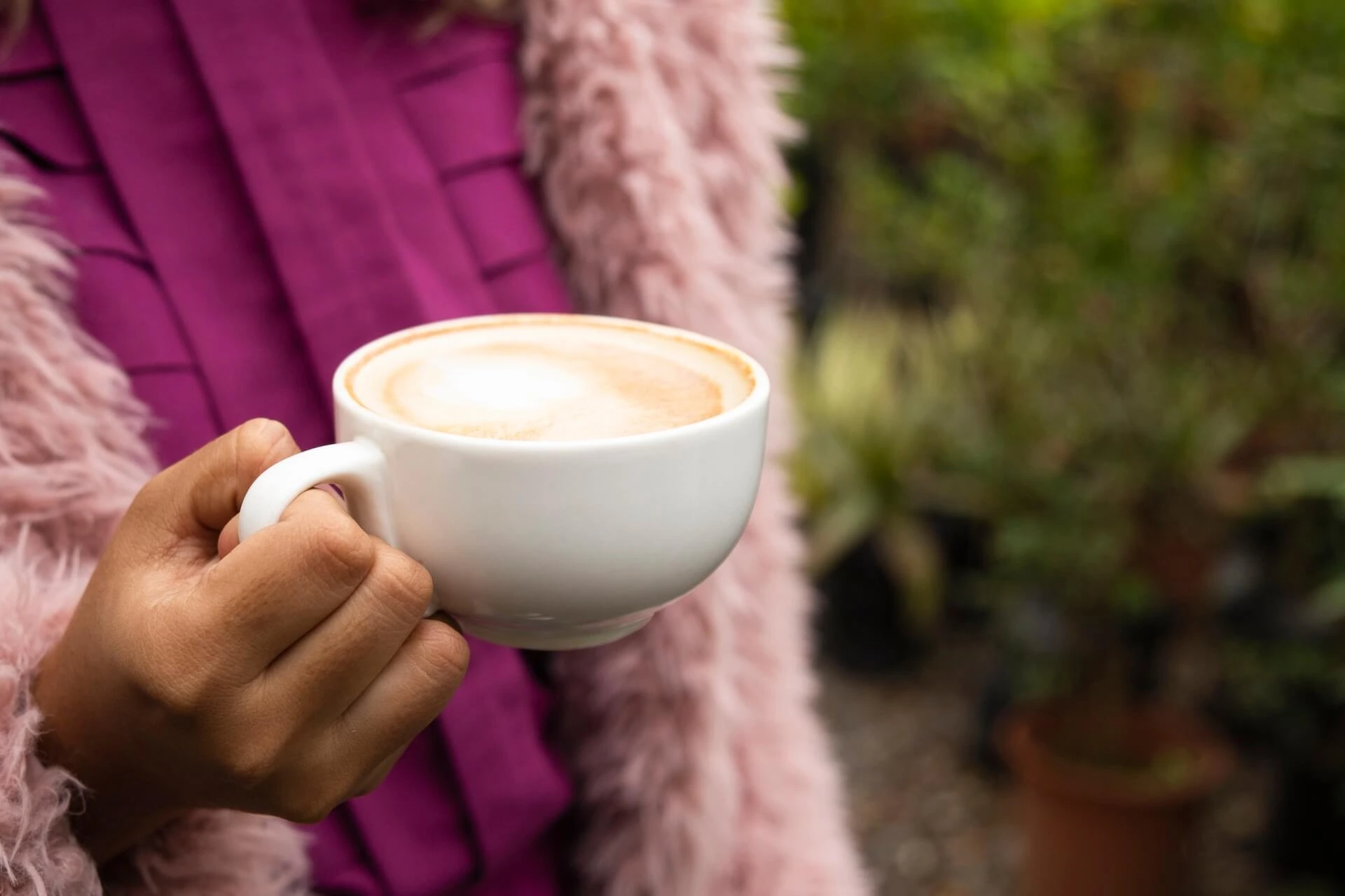 Woman holding mug of cappuccino